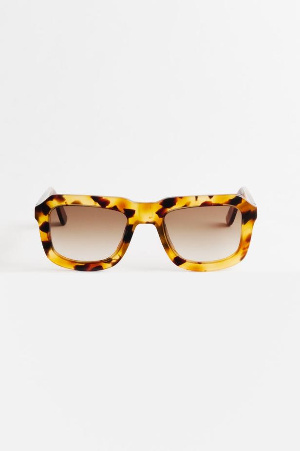 Eine Schildpatt-Sonnenbrille mit braunen Gläsern vor einem weißen Hintergrund.