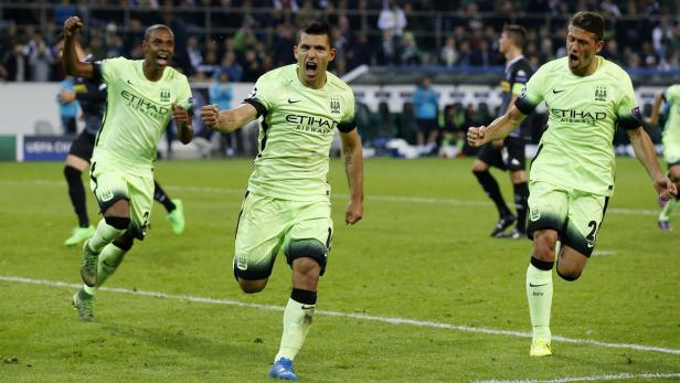 Drei Fußballspieler von Manchester City jubeln auf dem Spielfeld.