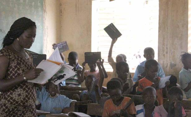 Eine Lehrerin liest ihren Schülern in einem Klassenzimmer vor.