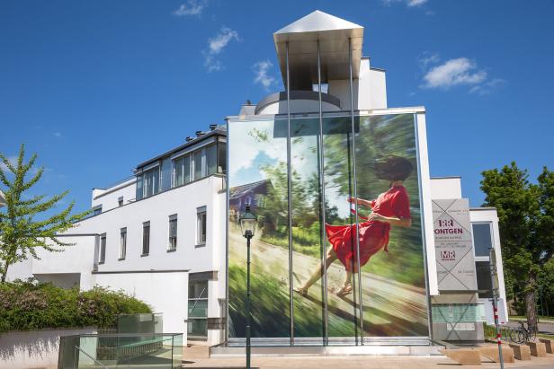 Ein modernes Gebäude mit einem großen Bild einer Frau in einem roten Kleid.