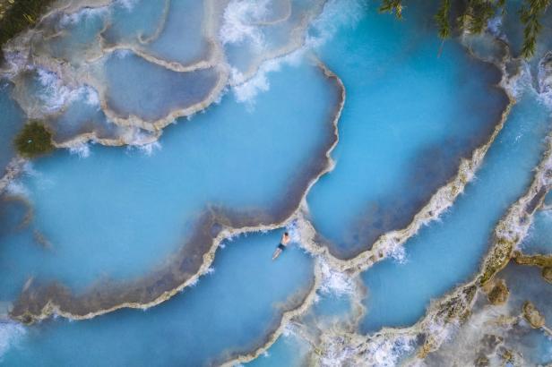Ein Mann schwimmt in den türkisfarbenen Becken von Pamukkale, Türkei.