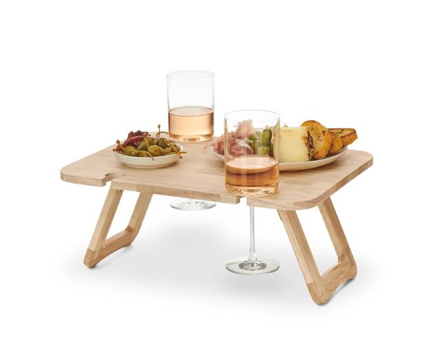 Ein kleiner Holztisch mit zwei Gläsern Roséwein und verschiedenen Speisen darauf.