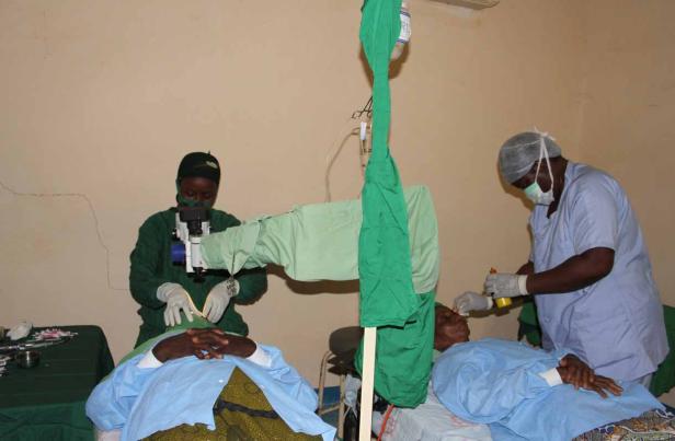 Zwei Chirurgen führen eine Augenoperation an einem Patienten durch.