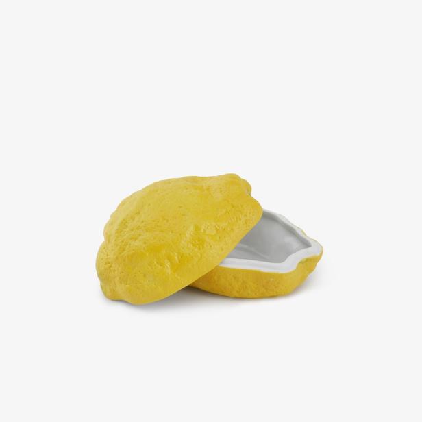 Eine offene, zitronenförmige Dose aus Keramik.