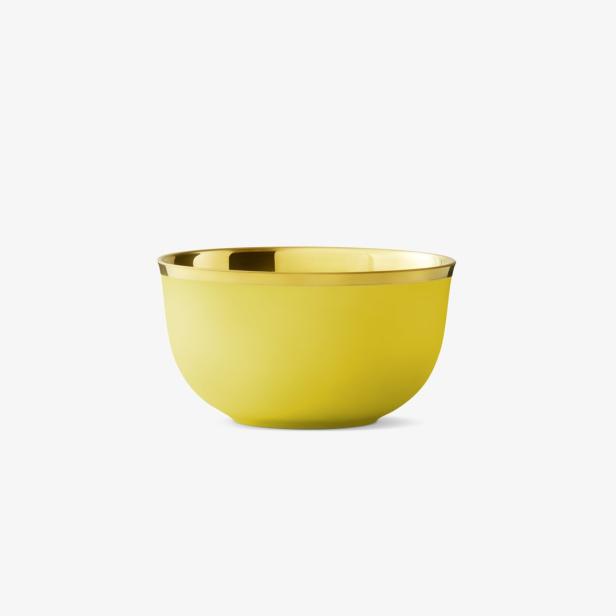 Eine gelbe Schale mit goldenem Rand auf einem weißen Hintergrund.