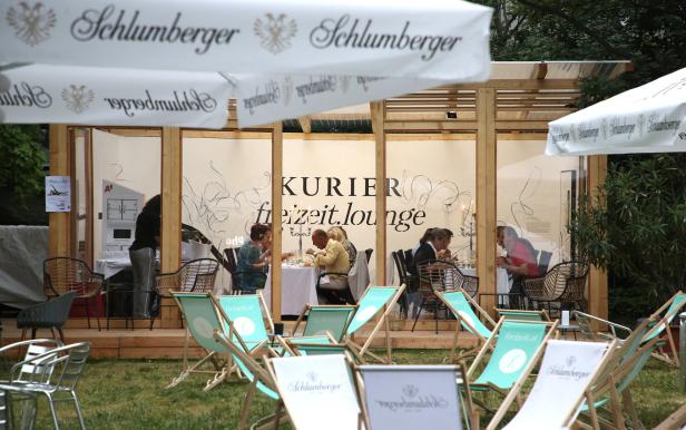 Gäste sitzen in der „Kurier“-Freizeit-Lounge im Freien.