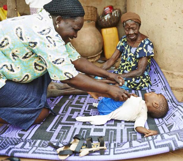 Eine Frau wickelt ein Baby, während eine ältere Frau zusieht.