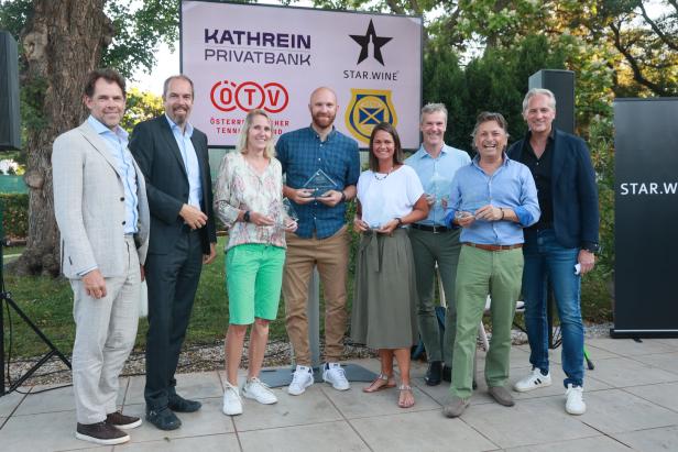Eine Gruppe von Personen posiert mit Auszeichnungen vor einem Banner der Kathrein Privatbank und Star.Wine.