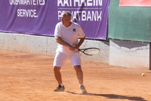 Ein Mann spielt Tennis auf einem Sandplatz.