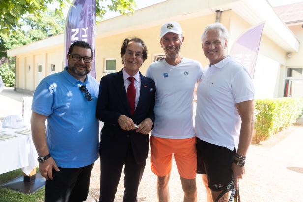 Eine Gruppe von vier Männern posiert im Freien für ein Foto.