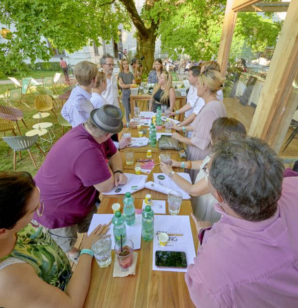 Eine Gruppe von Menschen nimmt an einer Gin-Tasting-Veranstaltung im Freien teil.