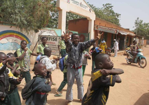 Eine Gruppe von Kindern steht vor dem „Groupe Scolaire CEFISE/BENAJA“ in Benin.