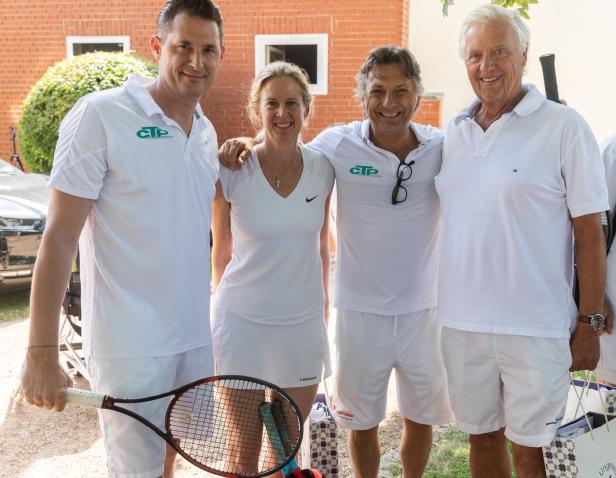 Eine Gruppe von vier Personen in Tenniskleidung posiert für ein Foto.