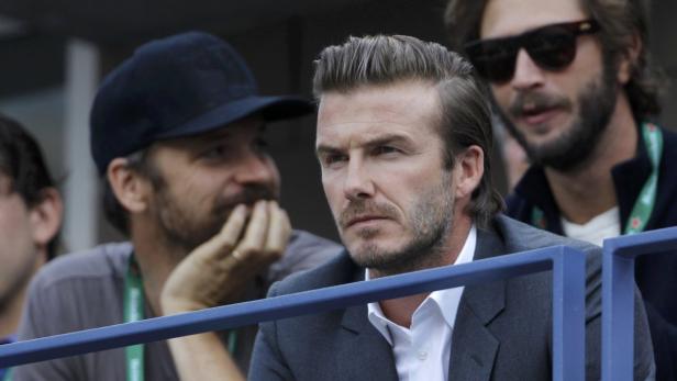 David Beckham bei einer Sportveranstaltung mit anderen Zuschauern.
