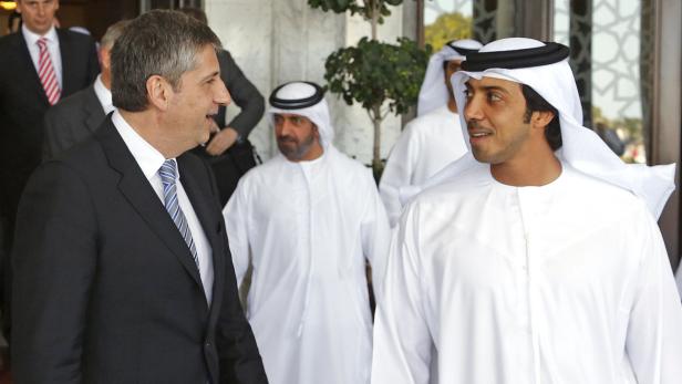 Ein Mann im Anzug unterhält sich mit einem Mann in traditioneller arabischer Kleidung.
