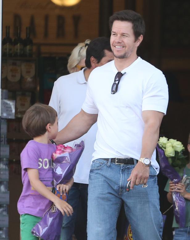 Mark Wahlberg mit seinem Sohn, der einen Blumenstrauß trägt.