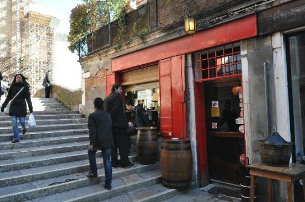 Menschen gehen eine Treppe hinauf zu einem Lokal in Venedig.