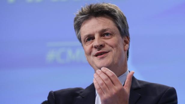 EU-Kommissar Jonathan Hill Ein Mann im Anzug gestikuliert vor einem blauen Hintergrund.