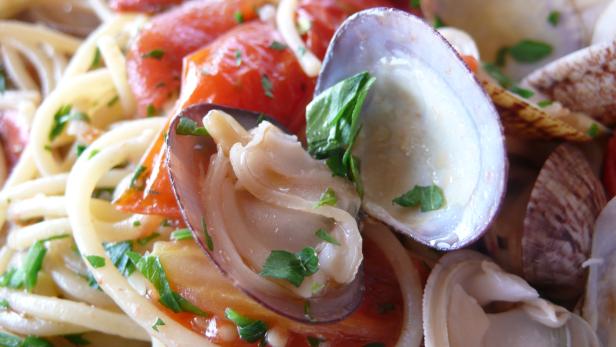 Nahaufnahme von Spaghetti mit Venusmuscheln und Tomaten.