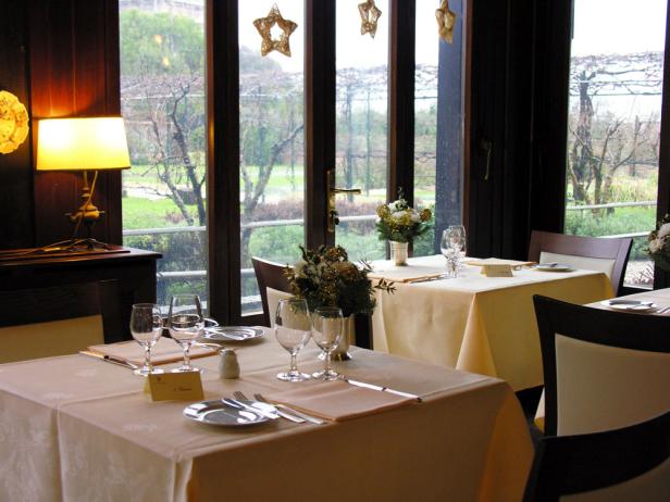 Ein gedeckter Tisch in einem Restaurant mit Blick auf einen Garten.