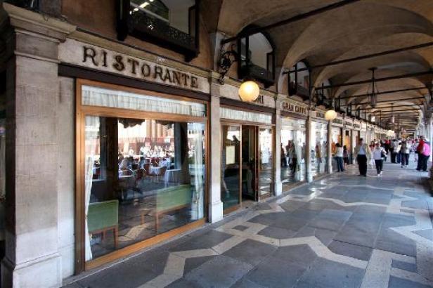 Ein überdachter Gang mit Geschäften und einem Ristorante in Venedig.