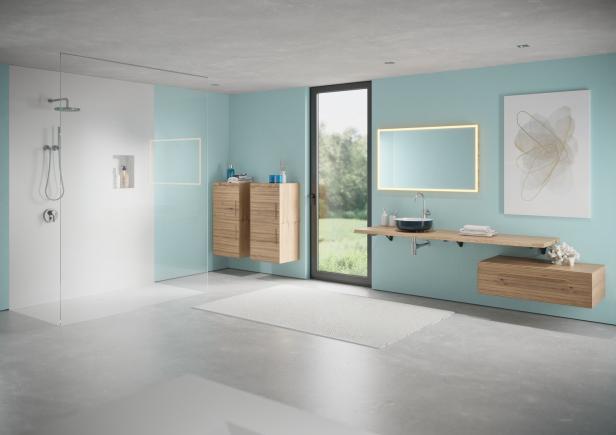 Ein modernes Badezimmer mit Dusche, Waschtisch und hellblauen Wänden.