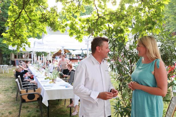 Ein Mann und eine Frau unterhalten sich bei einer Gartenparty.