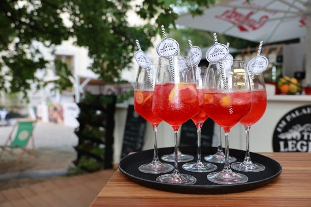Mehrere Gläser Aperol Spritz stehen auf einem Tablett.