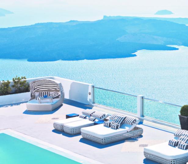 Ein luxuriöser Poolbereich mit Liegen und Blick auf das Meer.