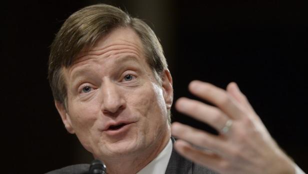 Ein Mann in einem Anzug gestikuliert mit der Hand.