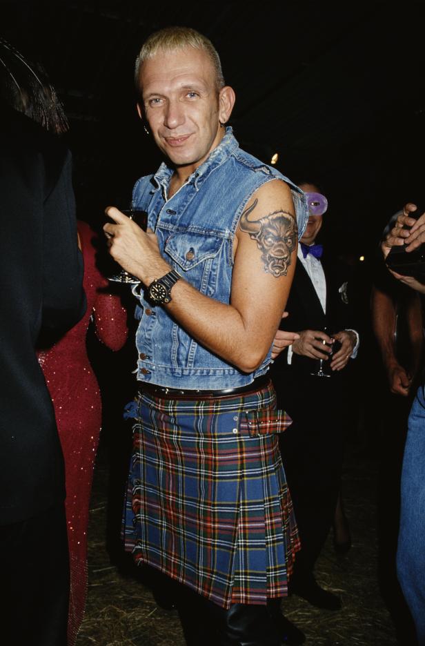 Jean-Paul Gaultier in einem Jeansweste und Schottenrock auf einer Party.