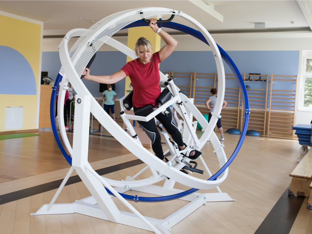 Eine Frau trainiert in einem Fitnessstudio mit einem Gyrotwister.