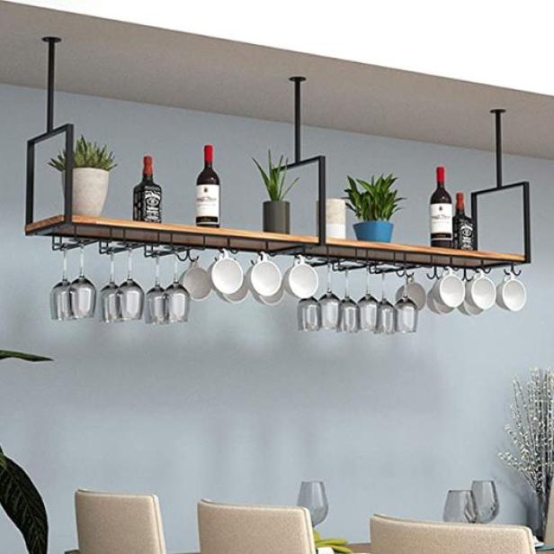 Ein hängendes Weinregal mit Gläsern, Tassen, Weinflaschen und Pflanzen an der Decke.