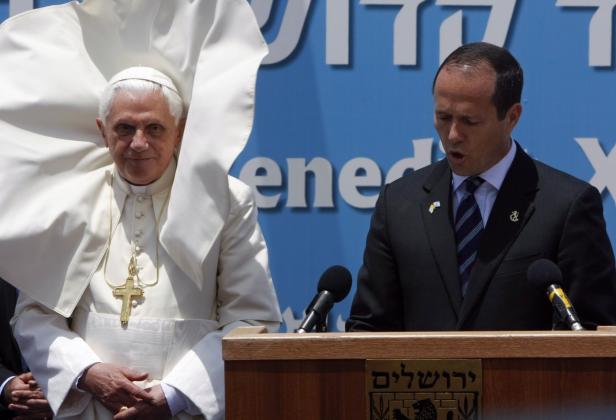 Papst Benedikt XVI. und ein Redner an einem Rednerpult.