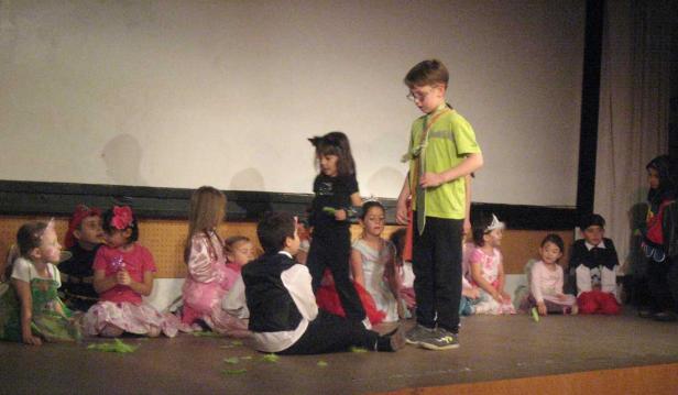 Eine Gruppe von Kindern in Kostümen steht auf einer Bühne.