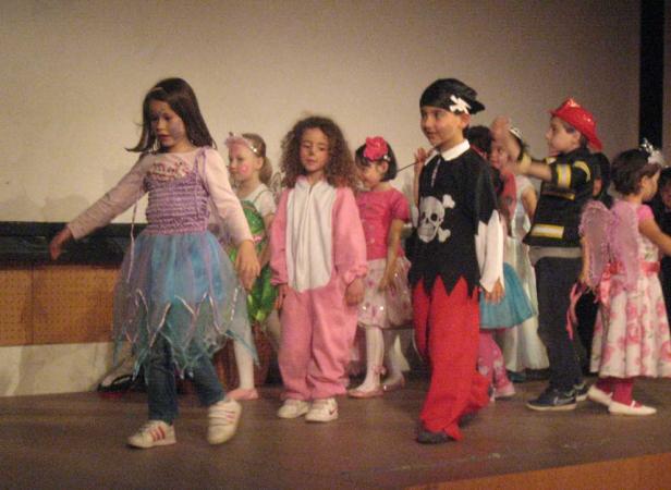 Eine Gruppe von Kindern in Kostümen steht auf einer Bühne.