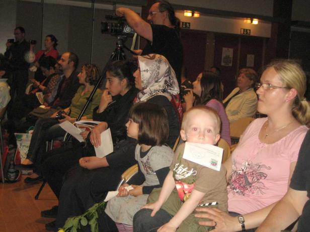 Eine Gruppe von Menschen sitzt bei einer Veranstaltung im Publikum.