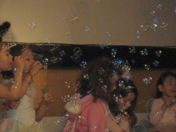 Mehrere Kinder pusten Seifenblasen.