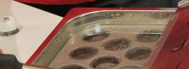 Ein Wasserbad mit einer Form für kleine, runde Speisen.