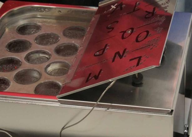 Ein Wasserbad mit einer Platte, auf der Buchstaben stehen.