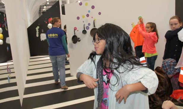 Kinder erkunden eine interaktive Ausstellung mit verschiedenen Installationen.