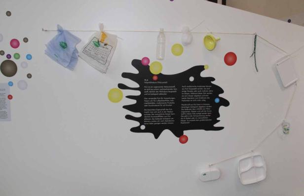 Eine Ausstellungstafel erklärt die Eigenschaften und Verwendung von PLA (Polymilchsäure).