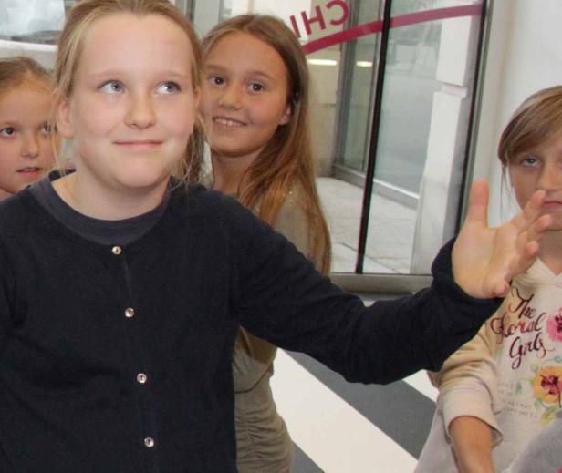 Eine Gruppe junger Mädchen steht zusammen und schaut in verschiedene Richtungen.