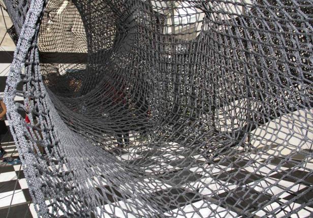 Ein Tunnel aus einem schwarzen Seilnetz.