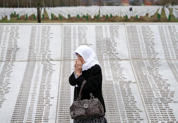 FILE PHOTO: A woman is seen near a grave of her family members in the Memorial centre Potocari, near Srebrenica