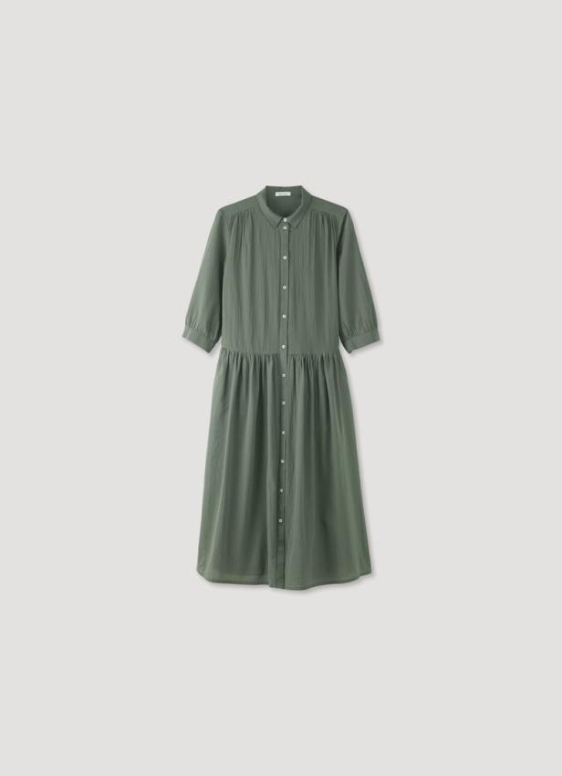 Ein grünes Hemdkleid mit Knöpfen und Dreiviertelärmeln.