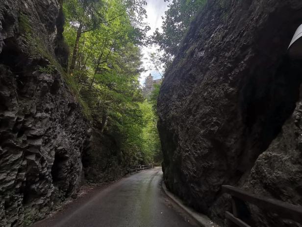 Eine Straße führt durch eine enge Schlucht mit steilen Felswänden.