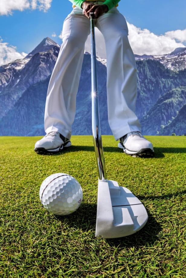 Man playing golf in Kaprun golf center against Kitzsteinhorn, Austria