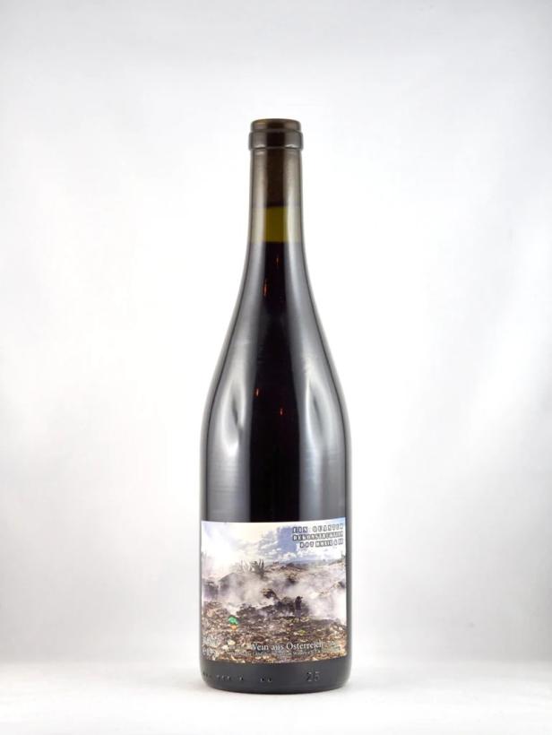 Eine Flasche Rotwein aus Österreich mit einem Etikett, das eine Mülldeponie zeigt.