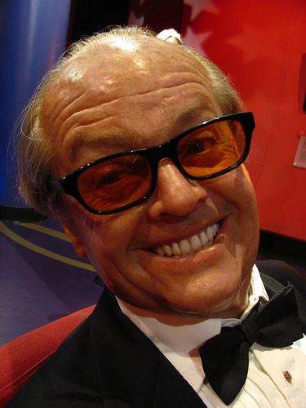 Ein Wachsabbild von Jack Nicholson mit schwarzer Fliege und getönter Brille lächelt.